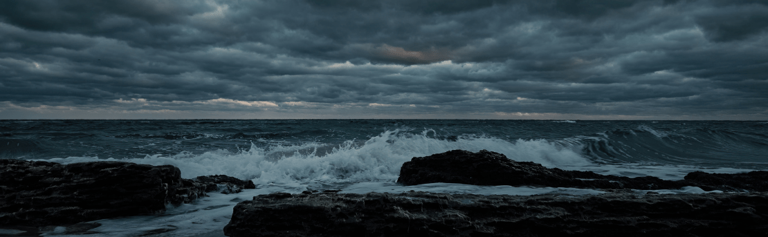 Dark clouds overlooking ocean waves.