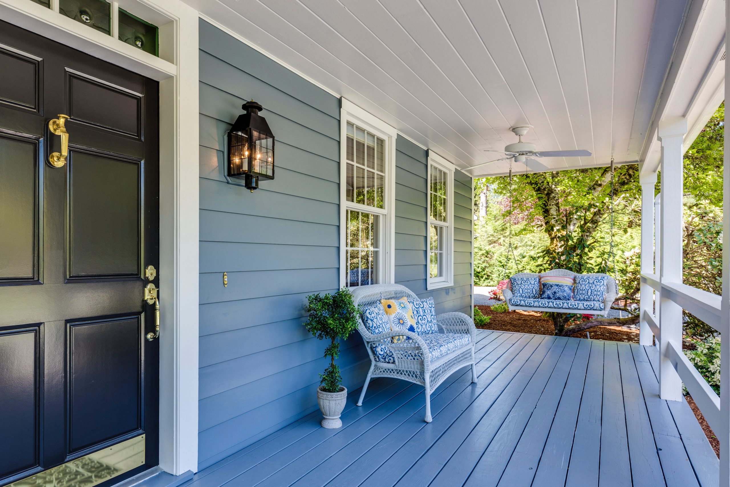 blue home with patio furniture on front porch