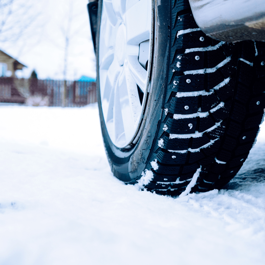 Close up of a car tire driving in the snow