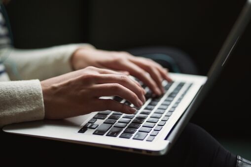 person working with a laptop on their lap