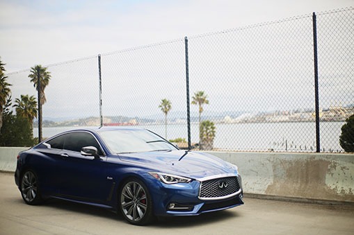 Blue two door infiniti overlooking the water