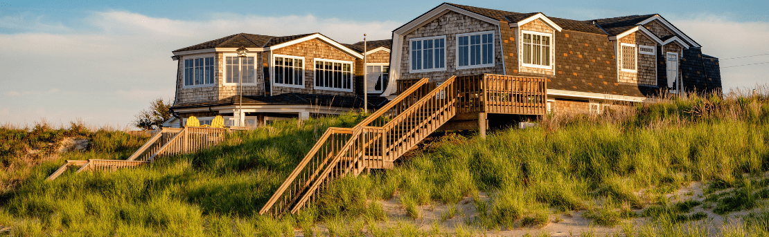 Beachfront property during sunset with stairs going down to the beach.